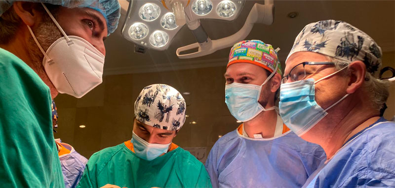 Cuatro cirujanos maxilofaciales de la clínica médica m4faces en una intervención en quirófano.